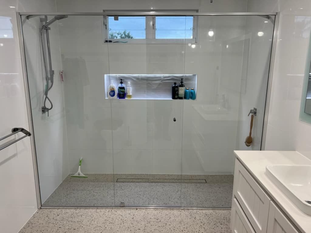 A large shower in a bathroom next to a sink — Gads Glass & Shower Screens in Albion Park, NSW
