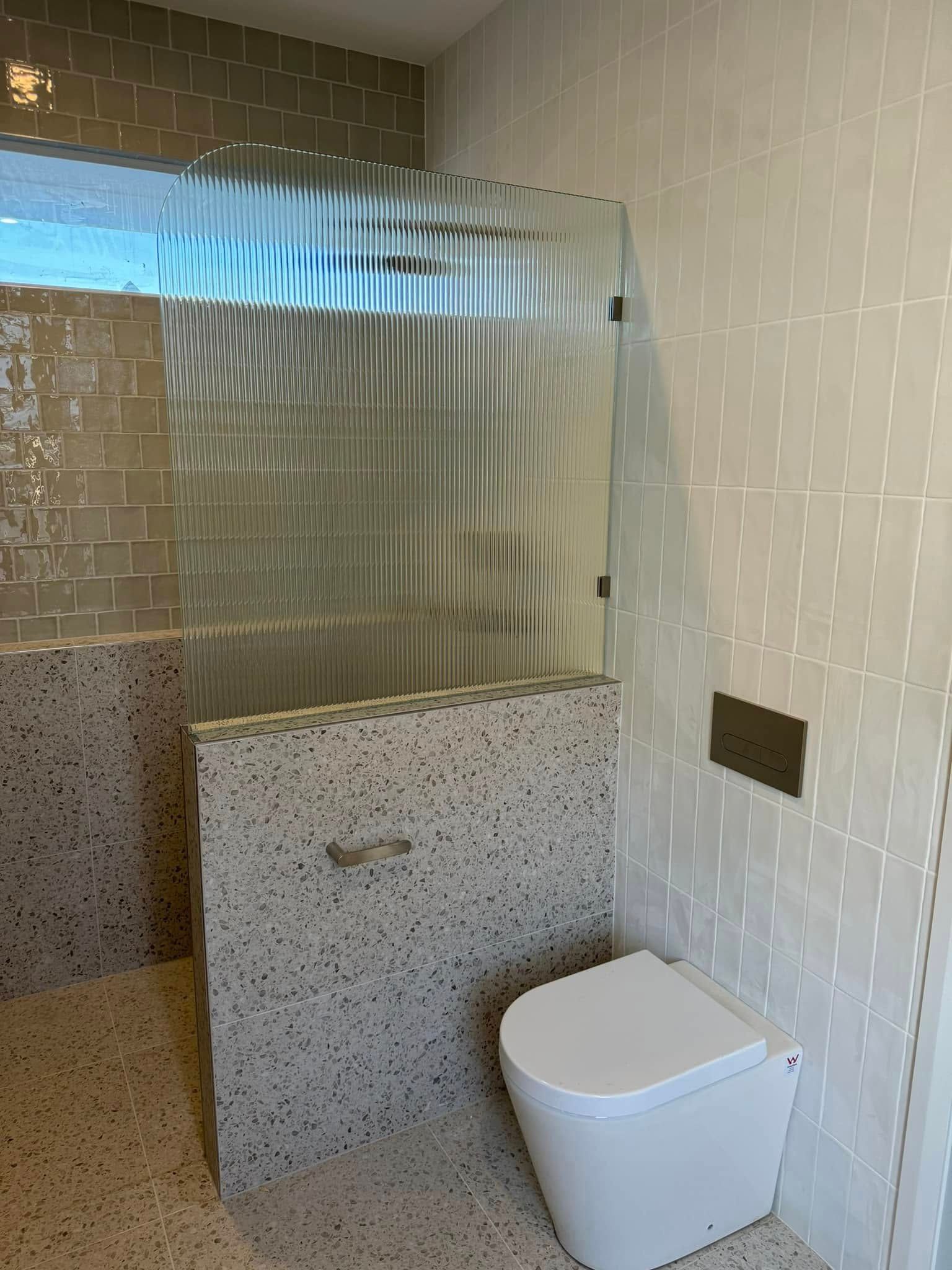 A bathroom with a half glass shower screen— Gads Glass & Shower Screens in Albion Park, NSW
