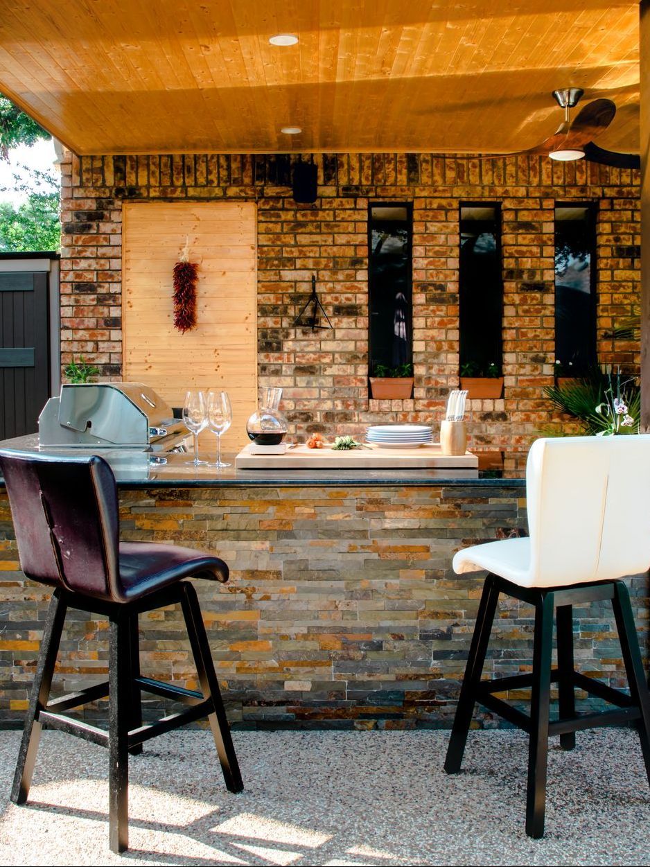 A bar with two chairs and a bottle of wine on it