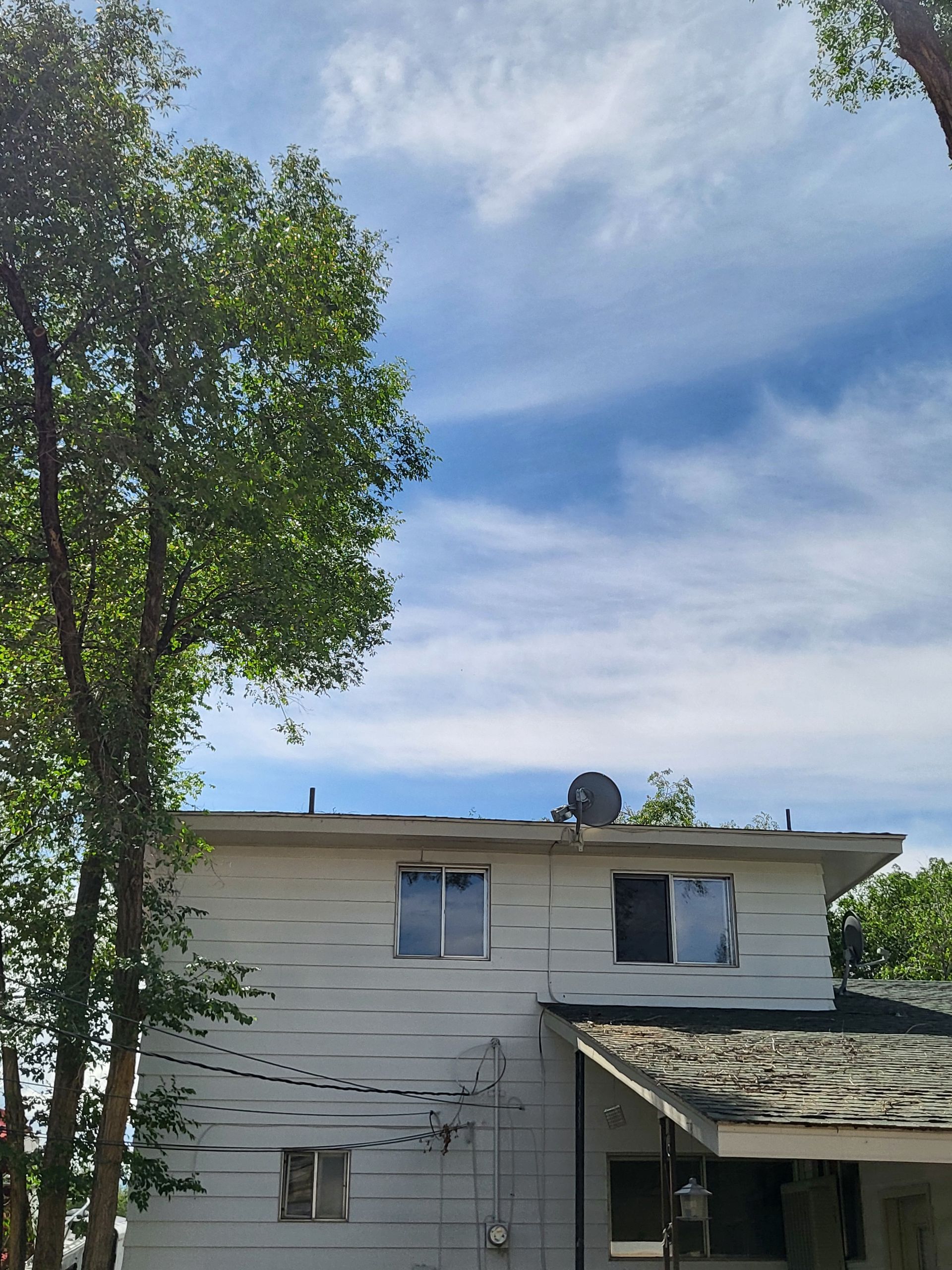 A white house with a satellite dish on the roof