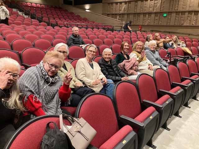 Grandfather showing photo album to three grandchildren on a couch.