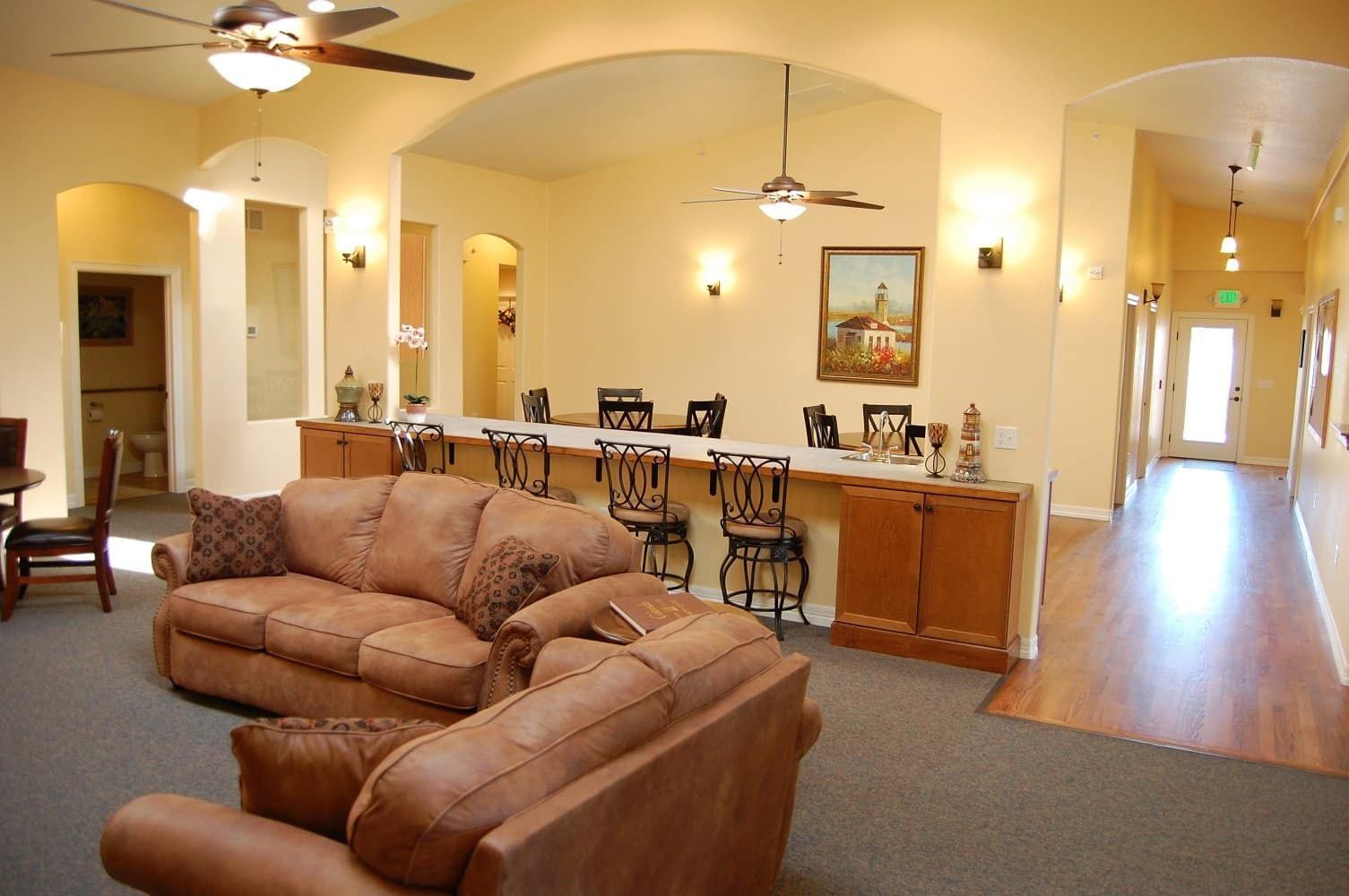 A living room with a couch and chairs and a ceiling fan