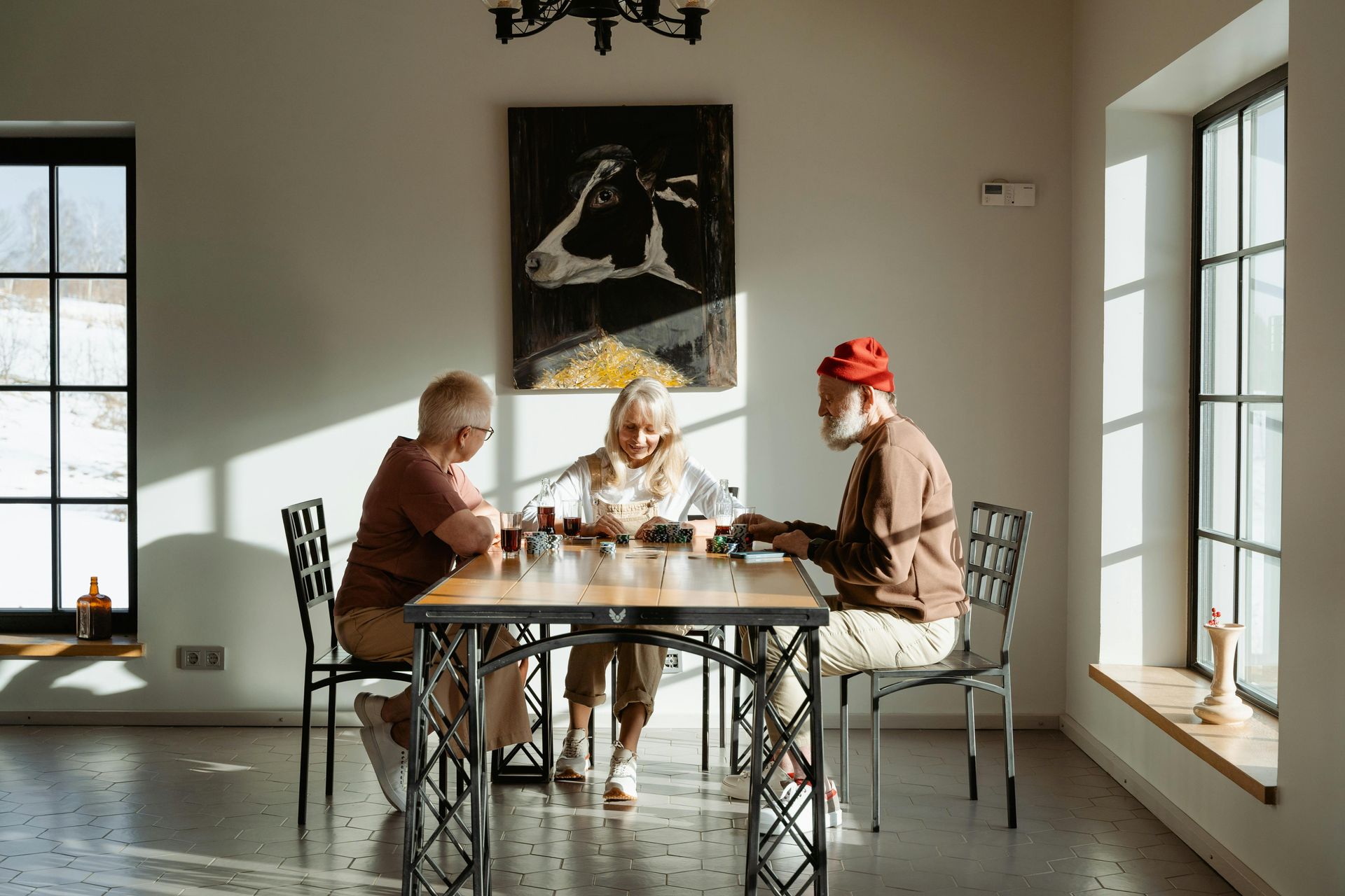 A group of people are sitting at a table in a living room.