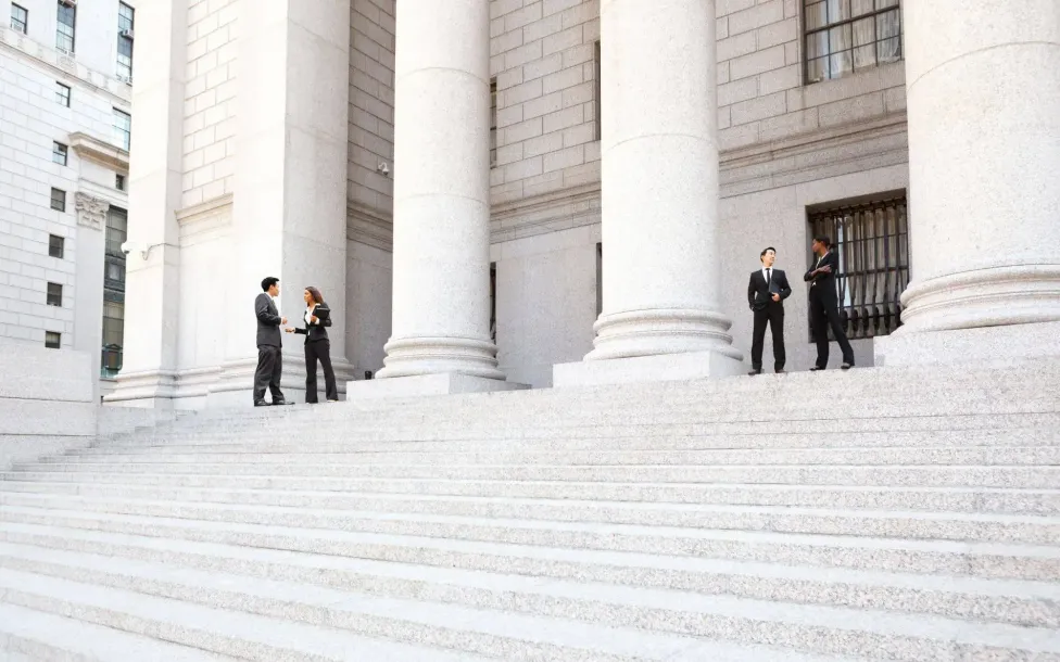 A group of people are standing on the steps of a building.