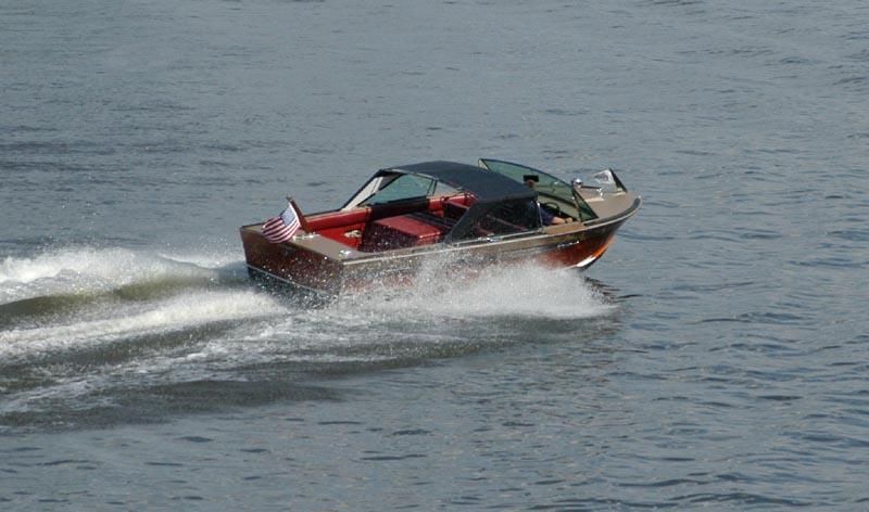 a small boat is floating on top of a body of water .