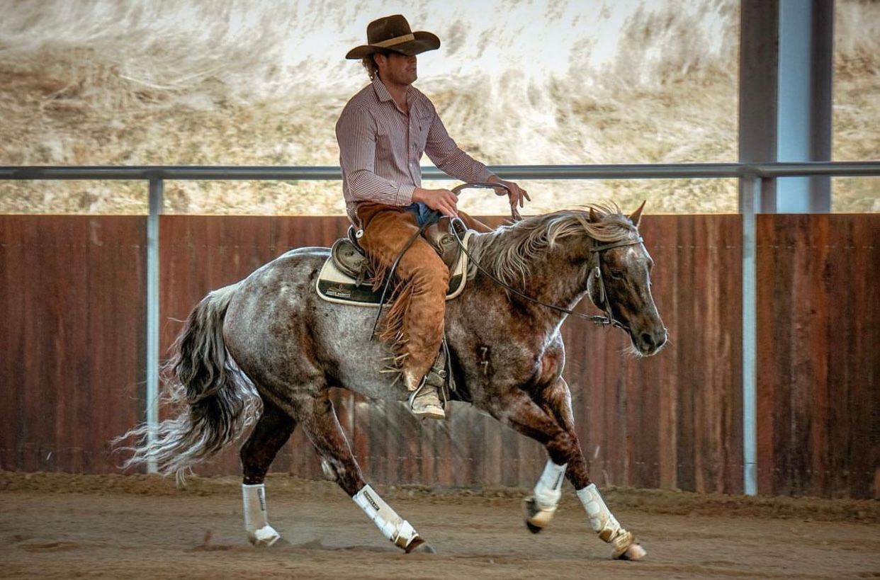 a man in a cowboy hat is riding a horse with a number 19 on the saddle .