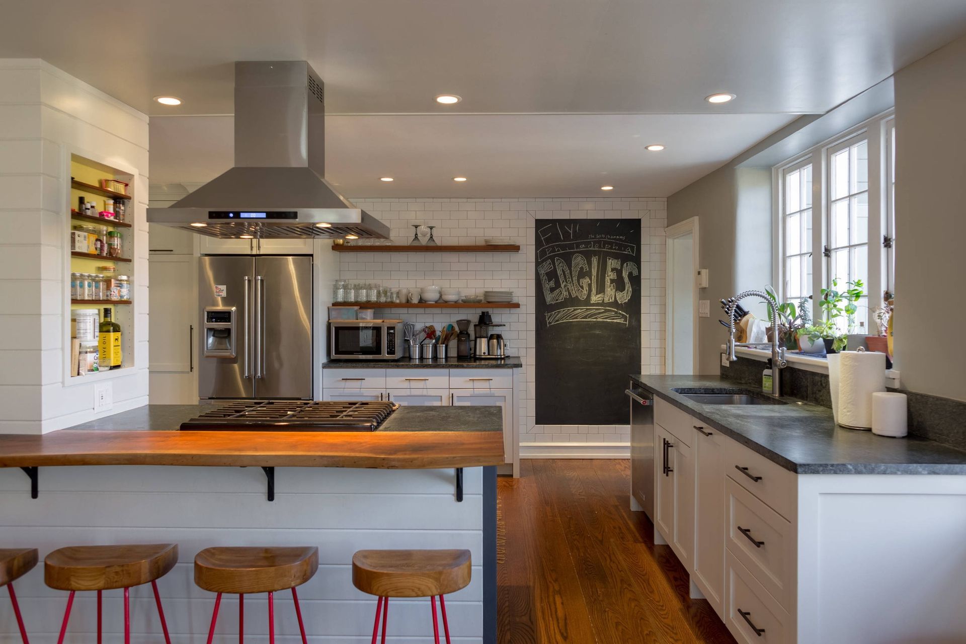 A kitchen with a stove , refrigerator , sink , and stools. James McCoy Remodeling Services Serving 19072,19003,19118,19444,19095 and surrounding areas