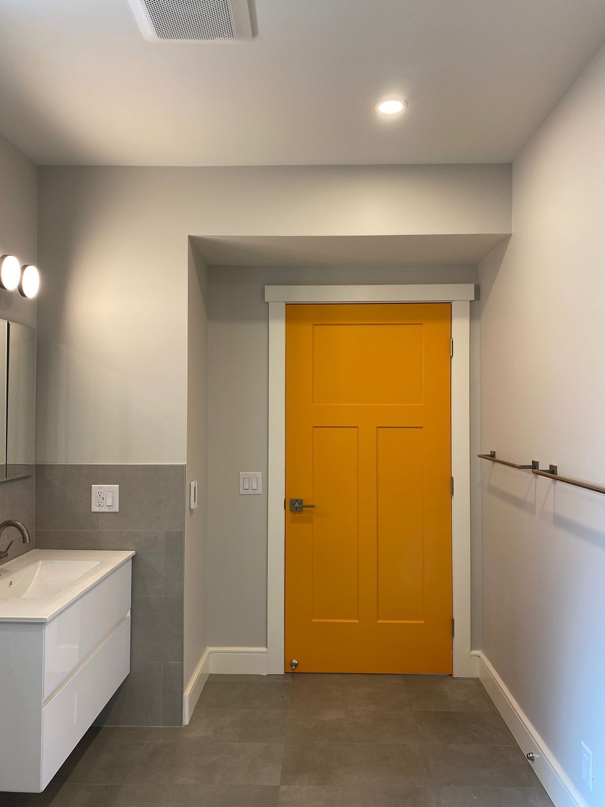 A bathroom with a yellow door and a sink