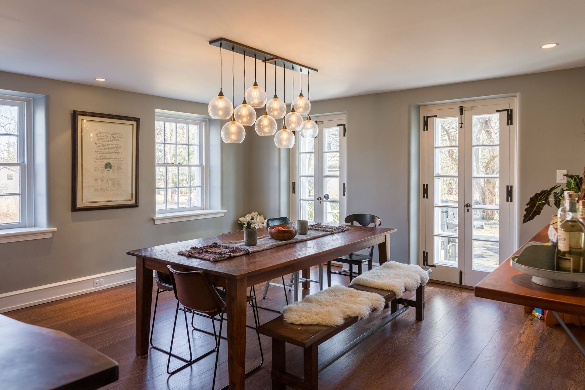 A dining room with a long wooden table and benches. James McCoy Remodeling Services Serving 19072,19003,19118,19444,19095 and surrounding areas