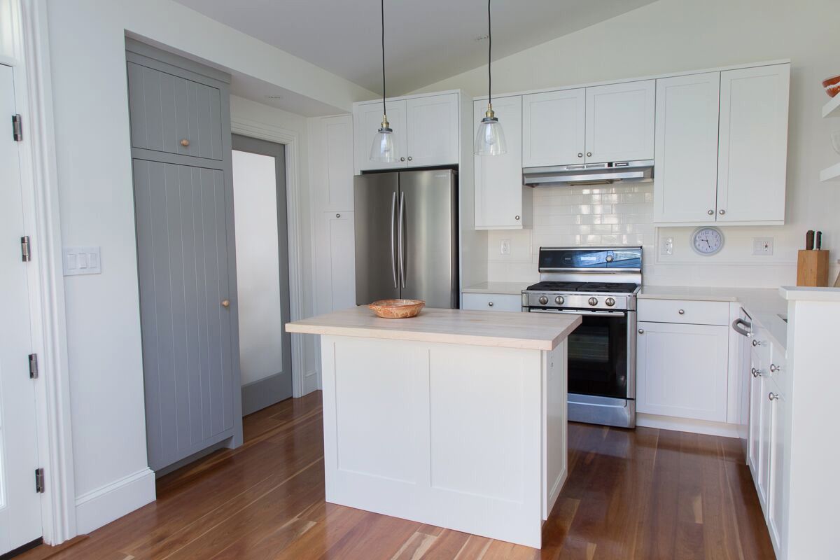 A kitchen with white cabinets , stainless steel appliances , and a large island. James McCoy Remodeling Services Serving 19072,19003,19118,19444,19095 and surrounding areas