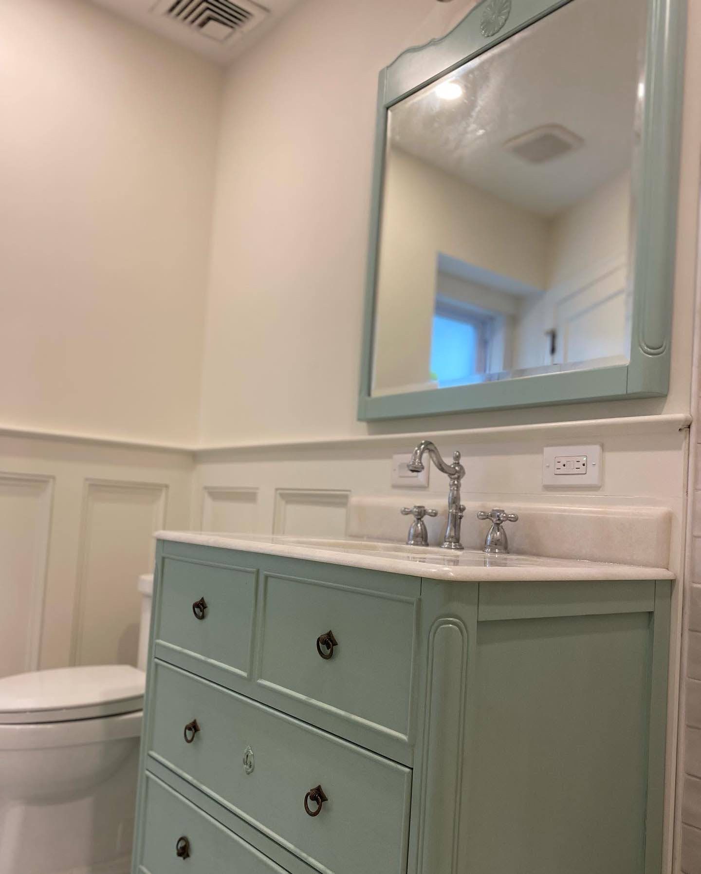 A bathroom with a toilet , sink , mirror and dresser. James McCoy Remodeling Services Serving 19072,19003,19118,19444,19095 and surrounding areas