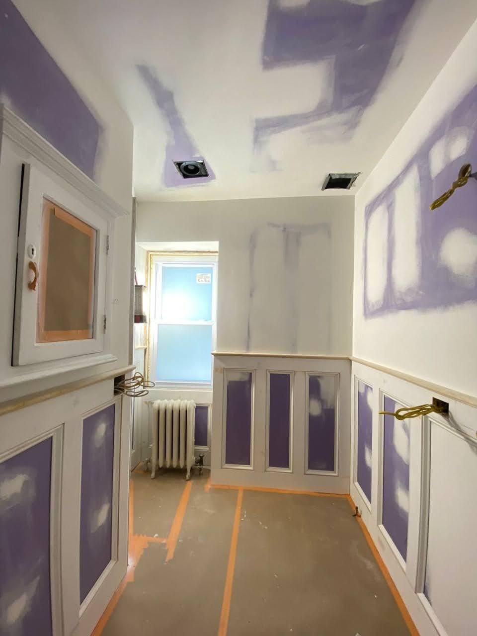 A hallway with purple walls and a window