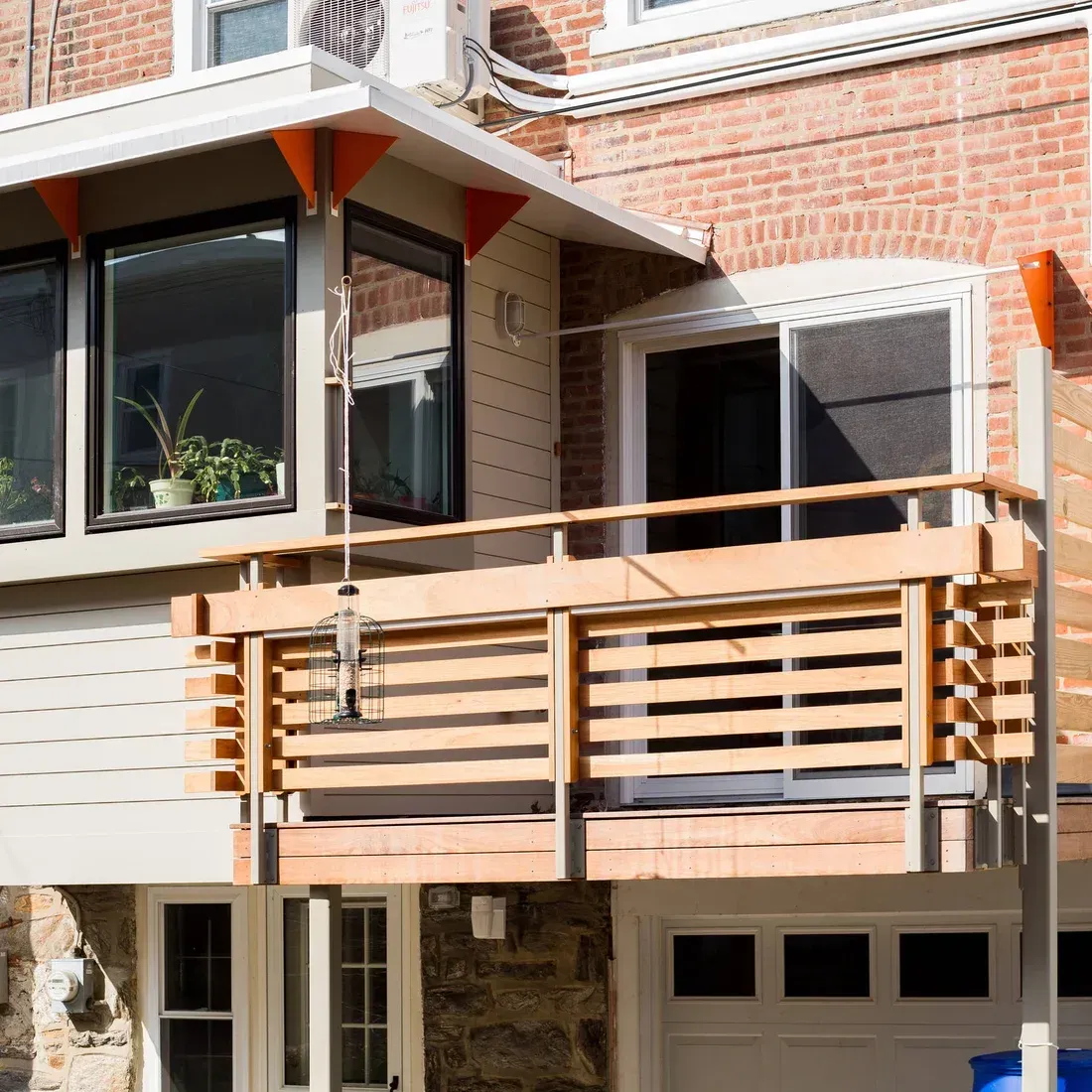 A brick building with a balcony and a sliding glass door. James McCoy Remodeling Services Serving 19072,19003,19118,19444,19095 and surrounding areas