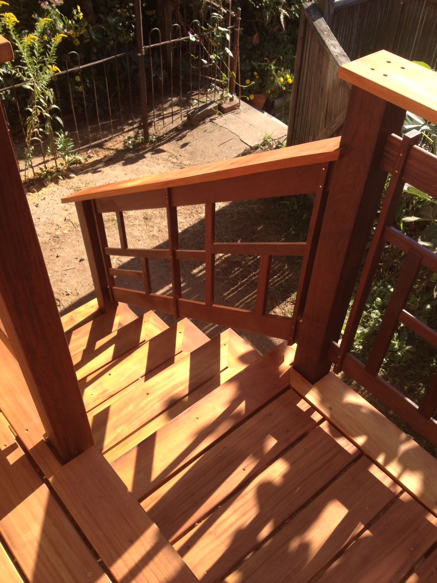A wooden deck with a railing and shadows on it. James McCoy Remodeling Services Serving 19072,19003,19118,19444,19095 and surrounding areas