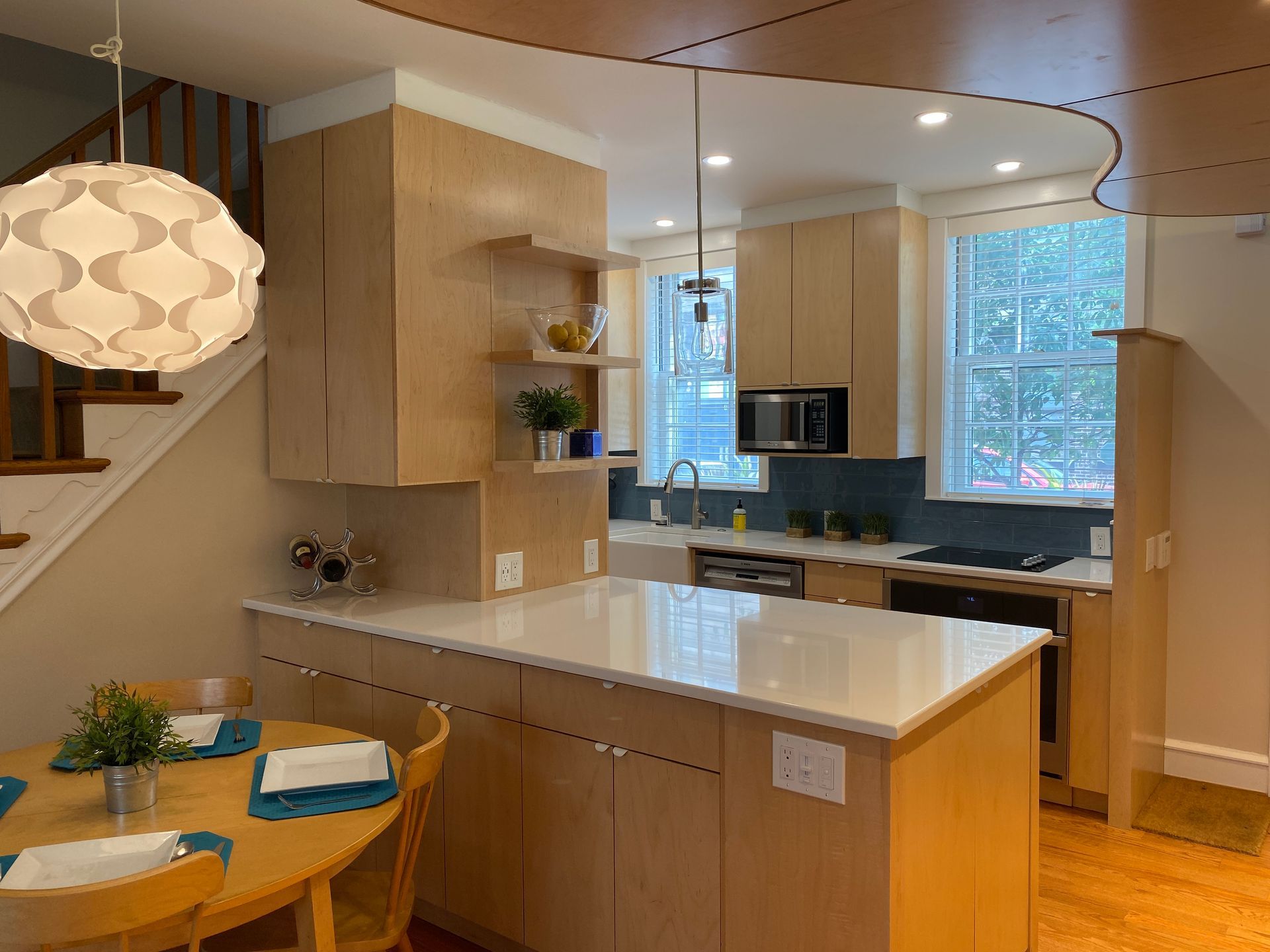 A kitchen with a table and chairs and a large island.