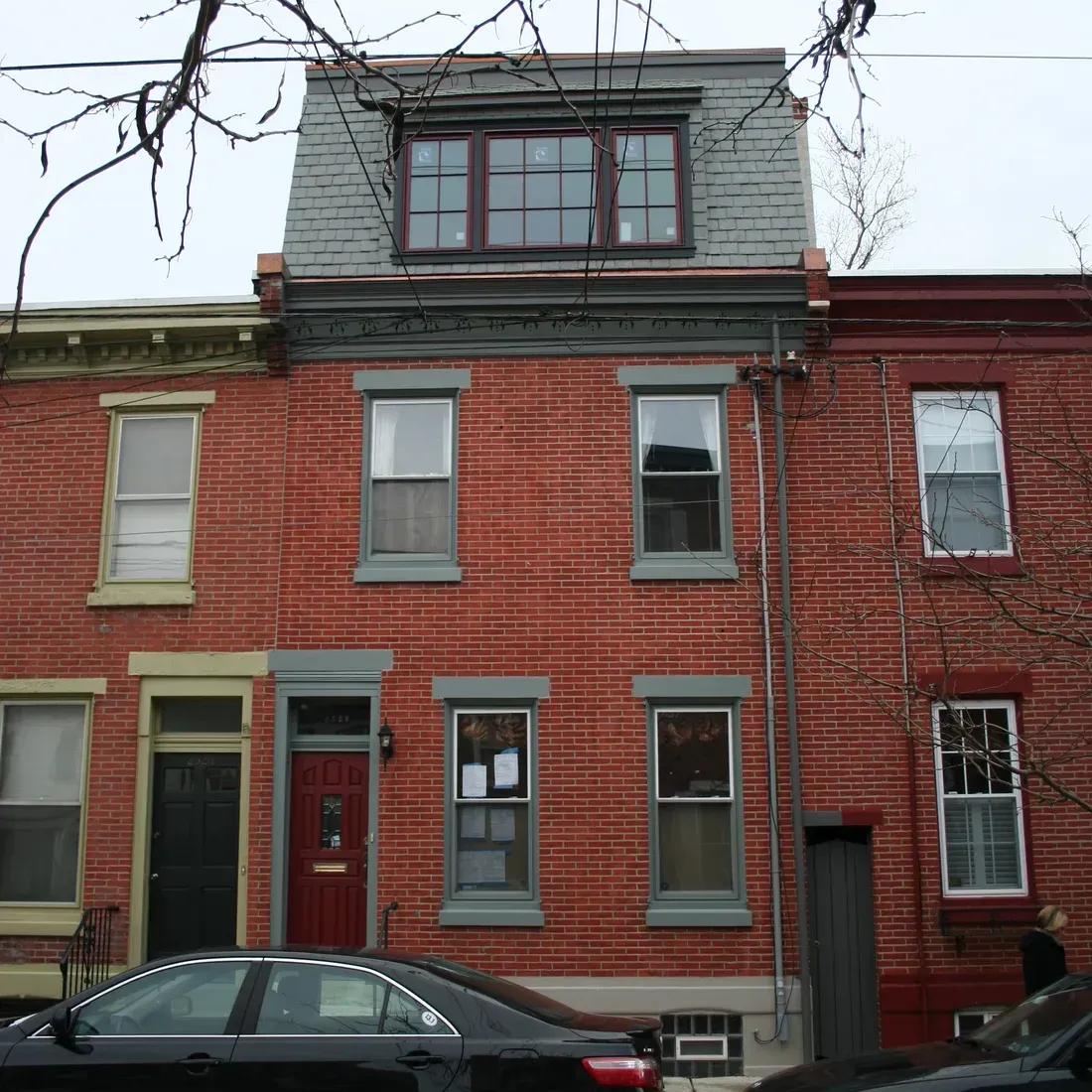 A black car is parked in front of a brick building James McCoy Remodeling Services Serving 19072,19003,19118,19444,19095 and surrounding areas