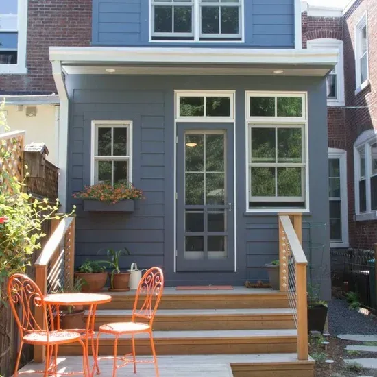 A blue house with orange chairs and tables in front of it. James McCoy Remodeling Services Serving 19072,19003,19118,19444,19095 and surrounding areas