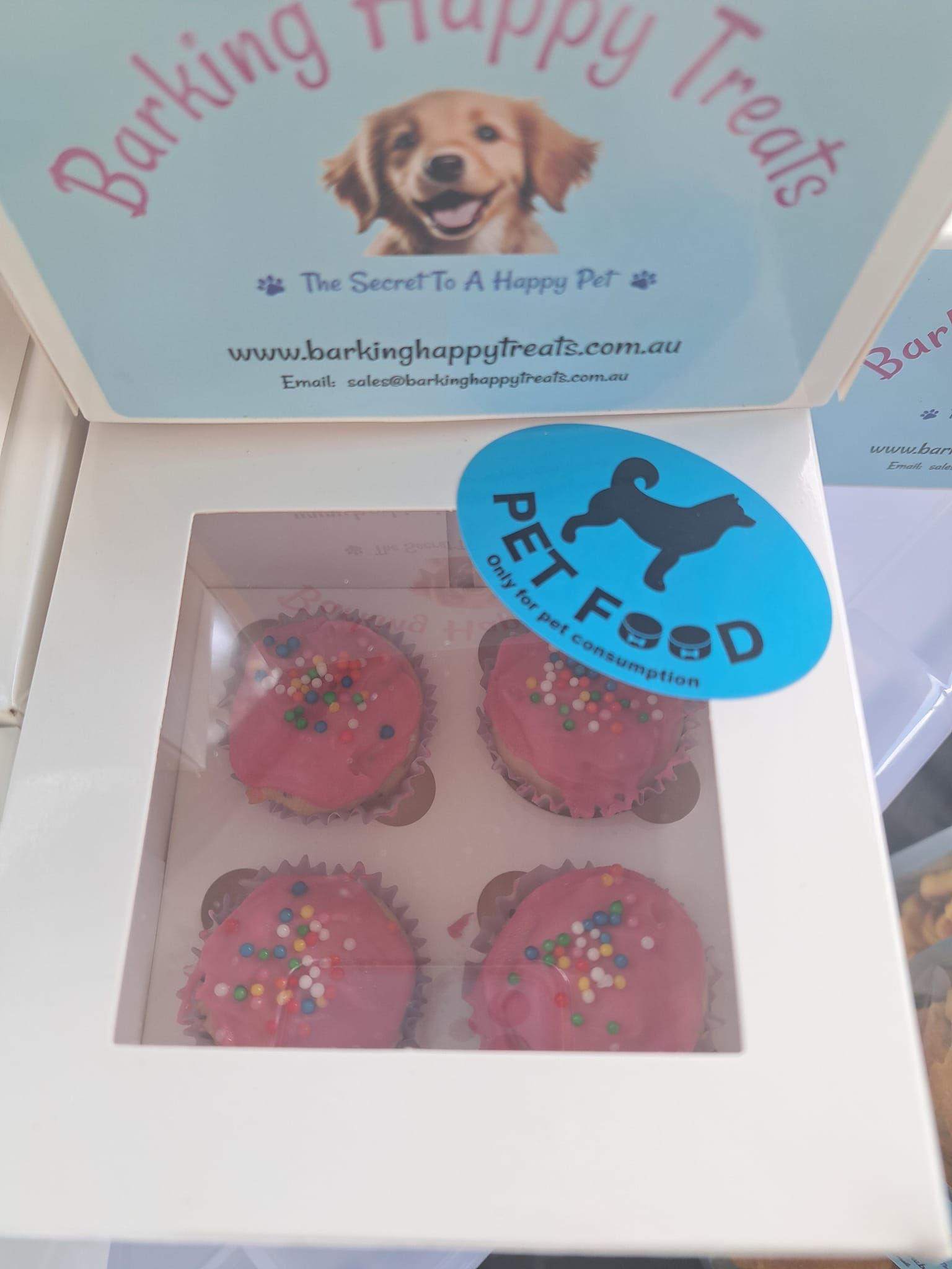 A Box Of Cupcakes With A Sticker That Says Pet Food — Barking Happy Treats In Collombatti, NSW