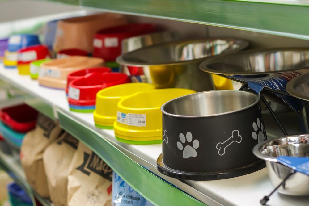A Variety Of Dog Bowls Are Lined Up On A Shelf In A Store — Barking Happy Treats In Collombatti, NSW