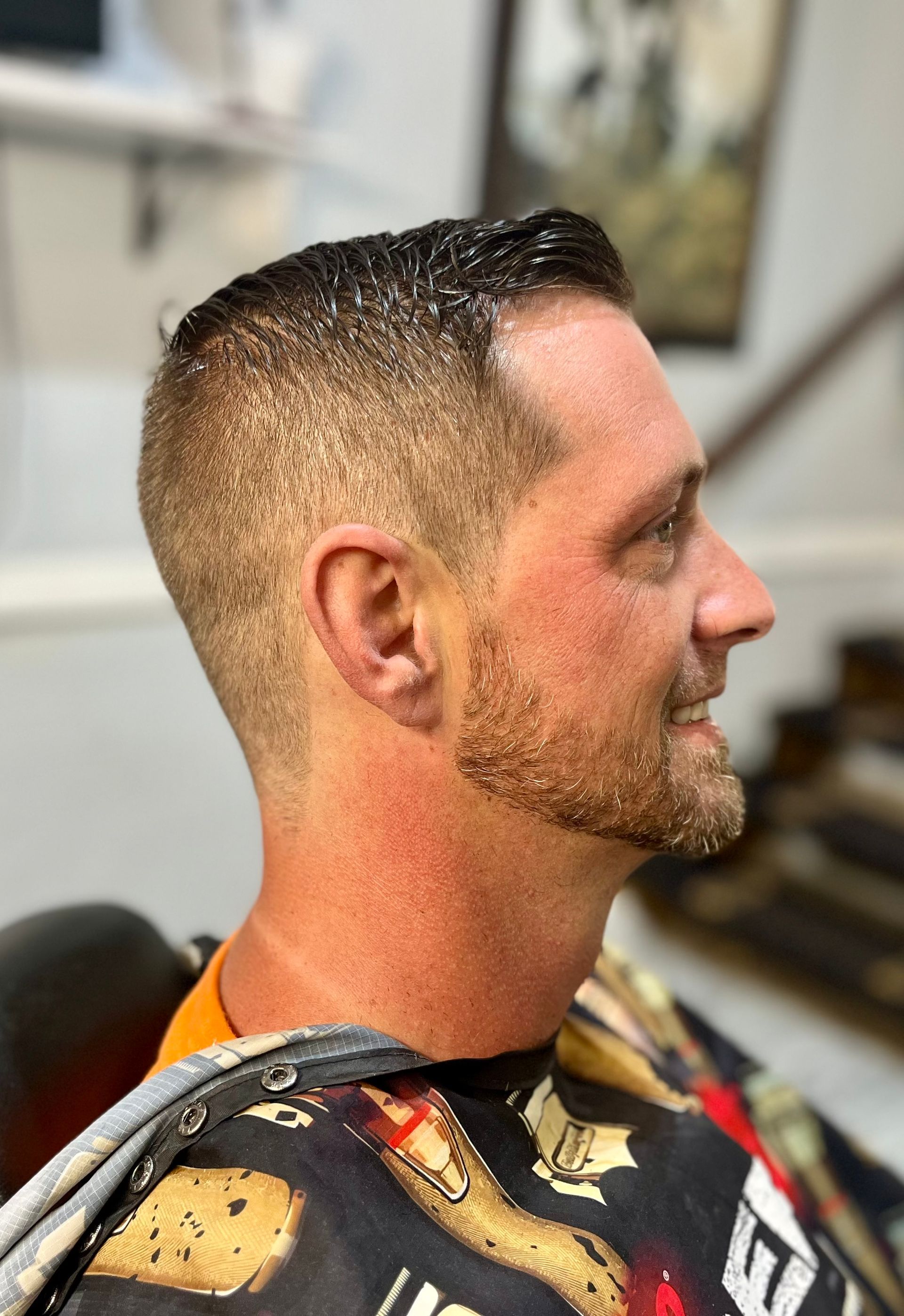 A man is getting his hair cut at a barber shop