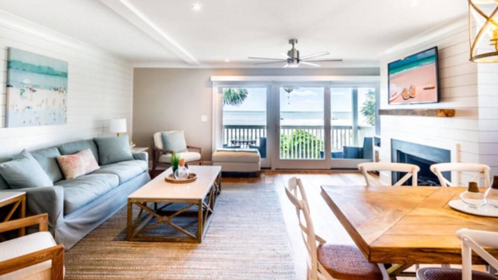 A living room with a couch , table , chairs and a fireplace.