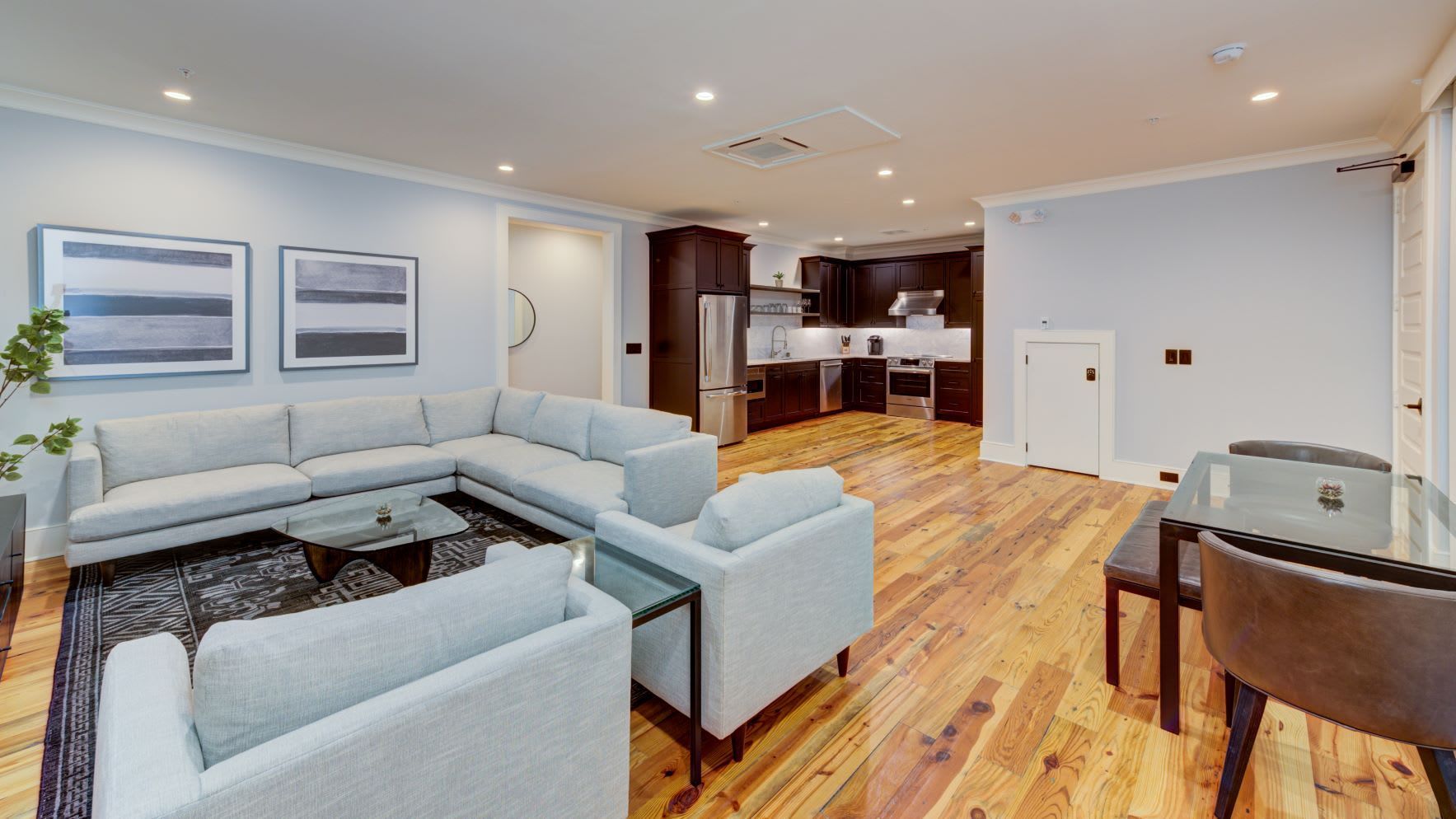 A living room with a large sectional couch , chairs , and a table.