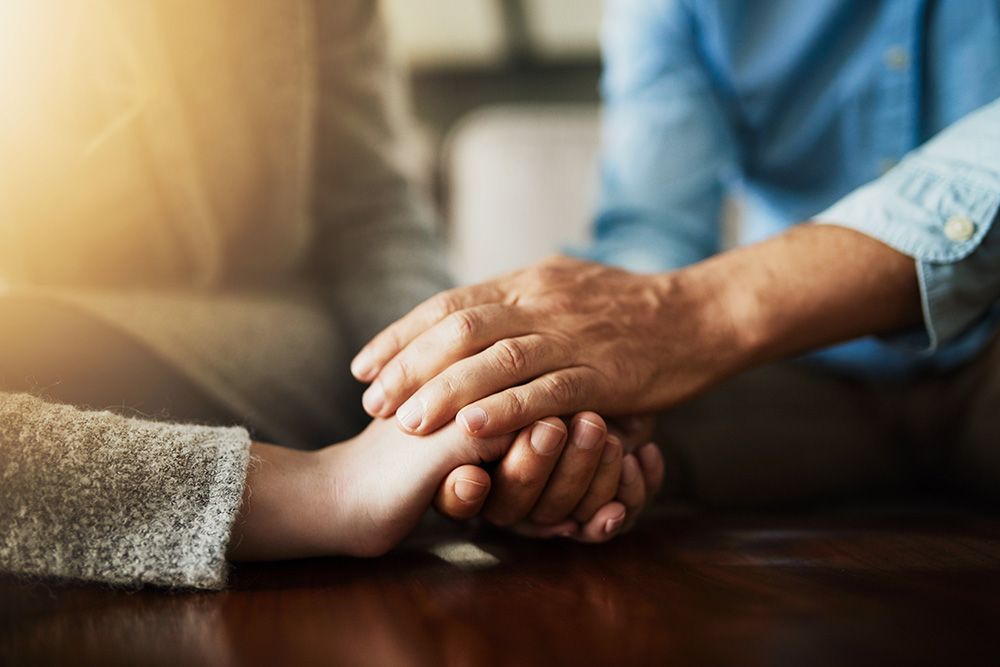 A man and a woman are holding hands on a table.