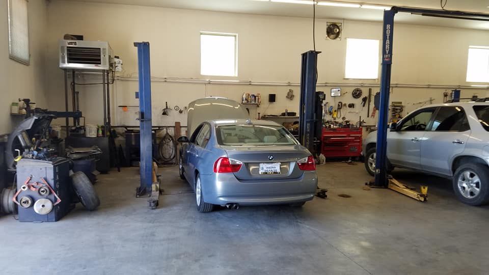 Vehicle Service Bays With Cars on Lifts Inside Repair Shop | Tom’s Auto & Imports