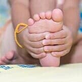 Little Girl Massaging Her Aching Feet — Children's Foot Problems in Chicago, IL
