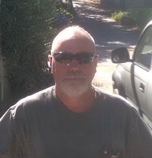 A woman is taking a selfie in front of a closet.