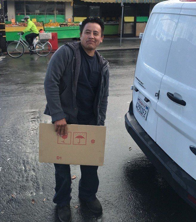A woman wearing glasses and a black hoodie smiles for the camera