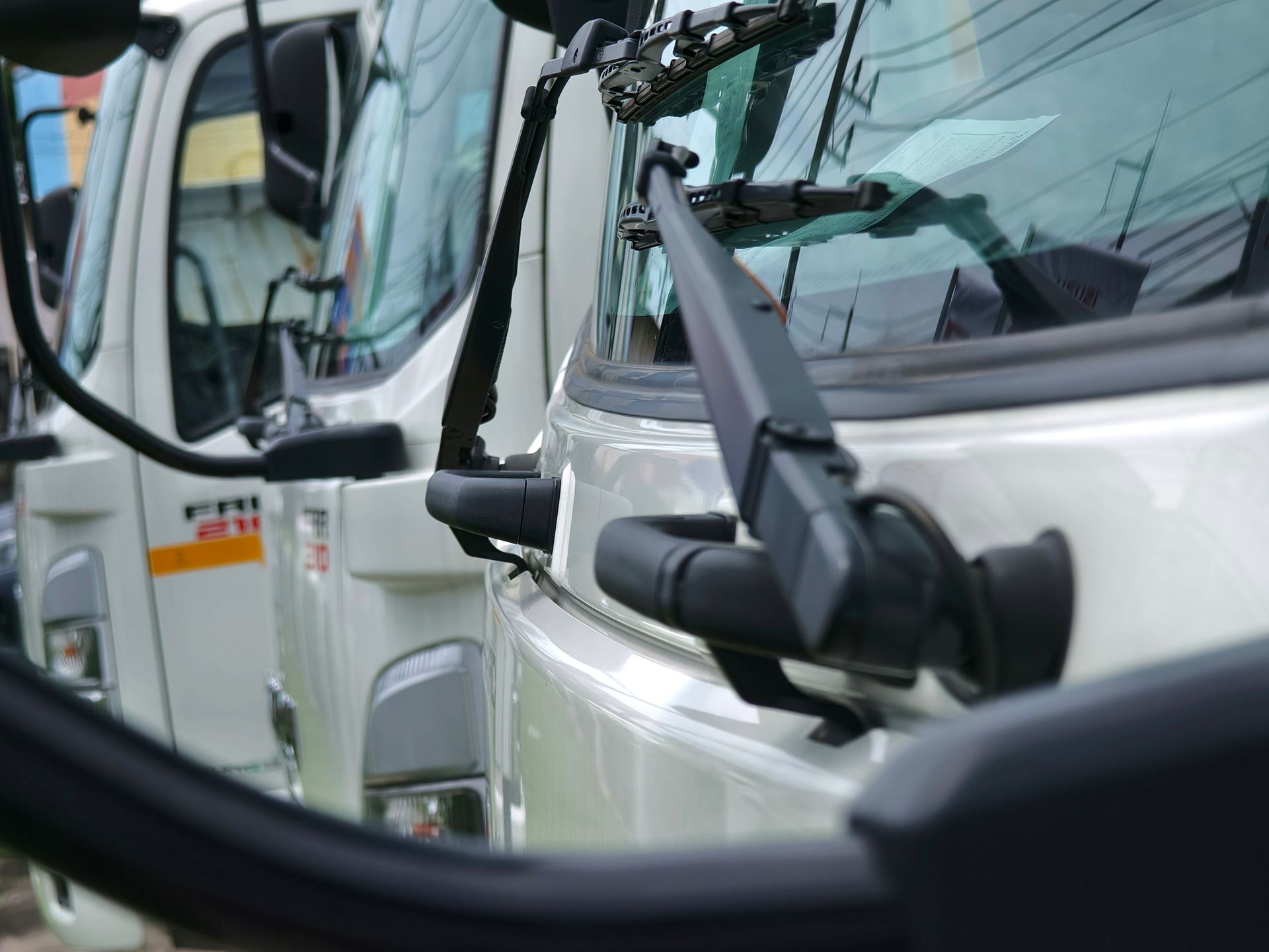 A Row of White Trucks Are Parked Next to Each Other.