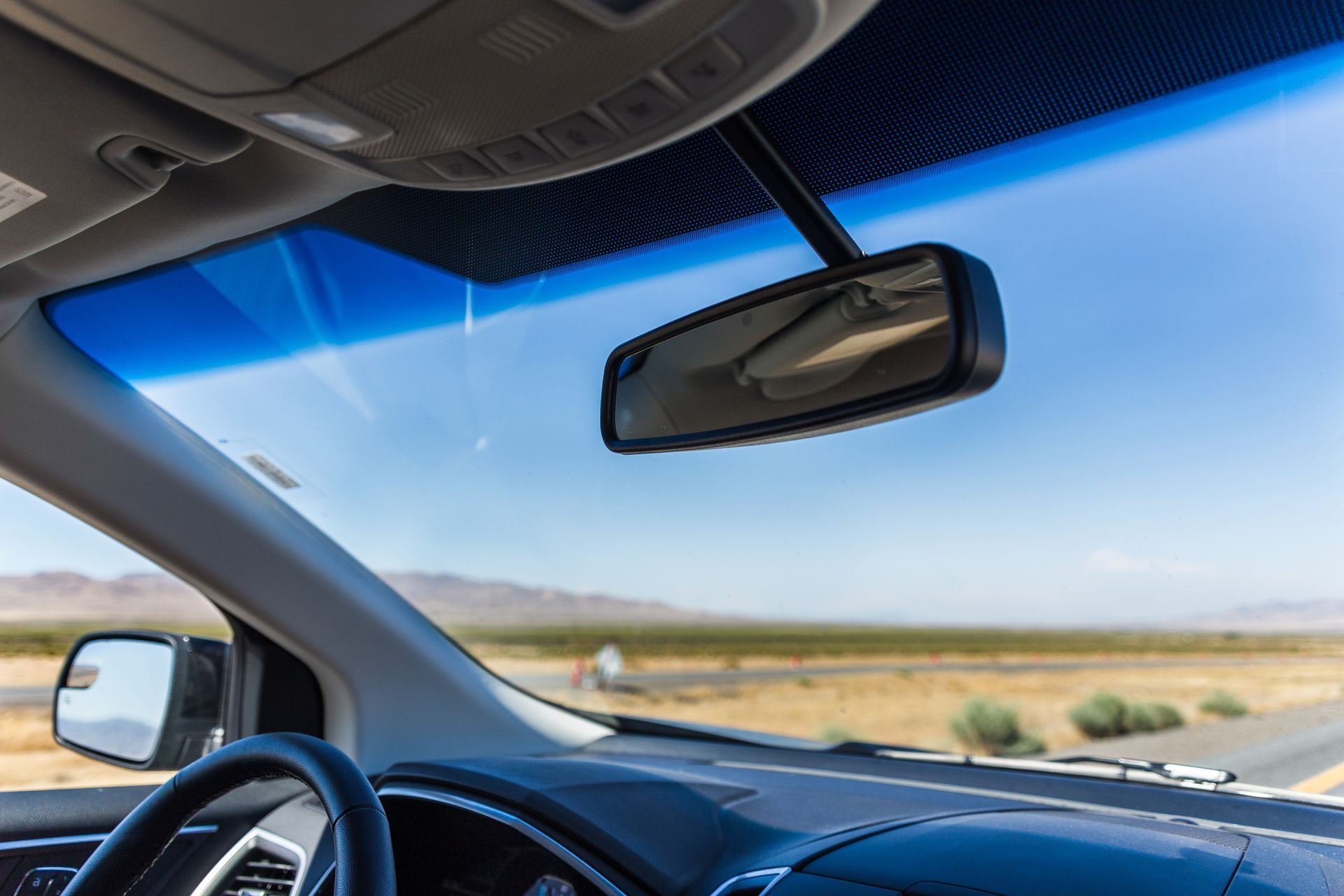 The Inside of A Car with A Rear View Mirror and Windshield.