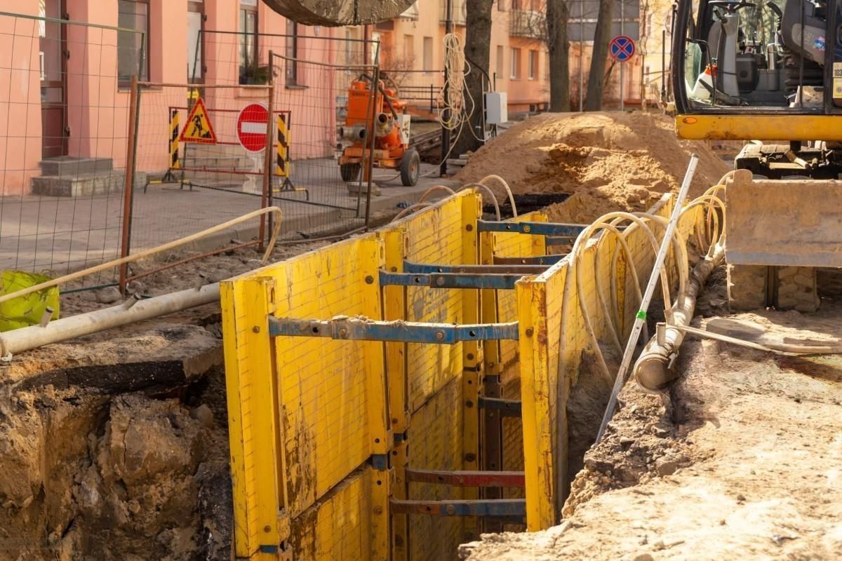 A construction site with a yellow barrier and a bulldozer.