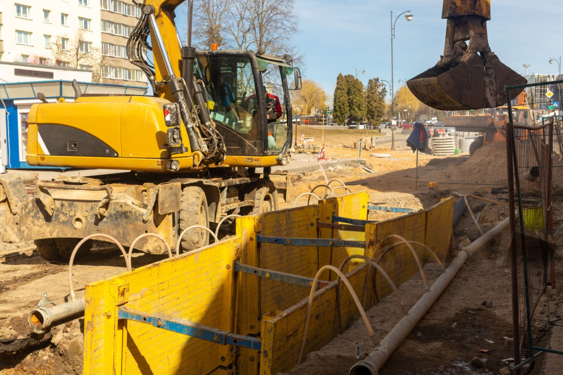 A yellow excavator is working on a construction site.