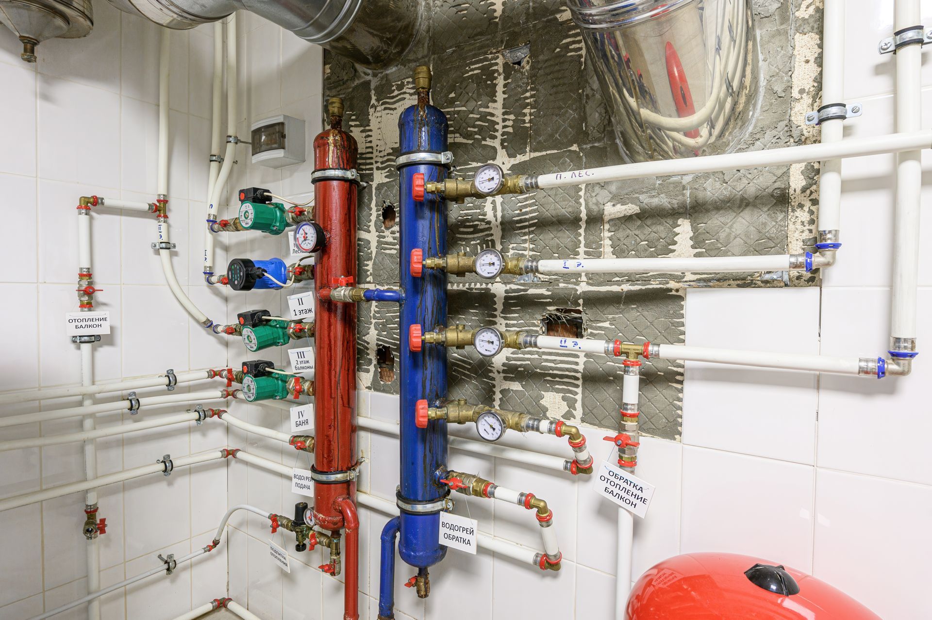 Complex plumbing system with pipes, gauges, pumps, and tanks in a tiled room. Complex plumbing system with pipes, gauges, pumps, and tanks in a tiled room.