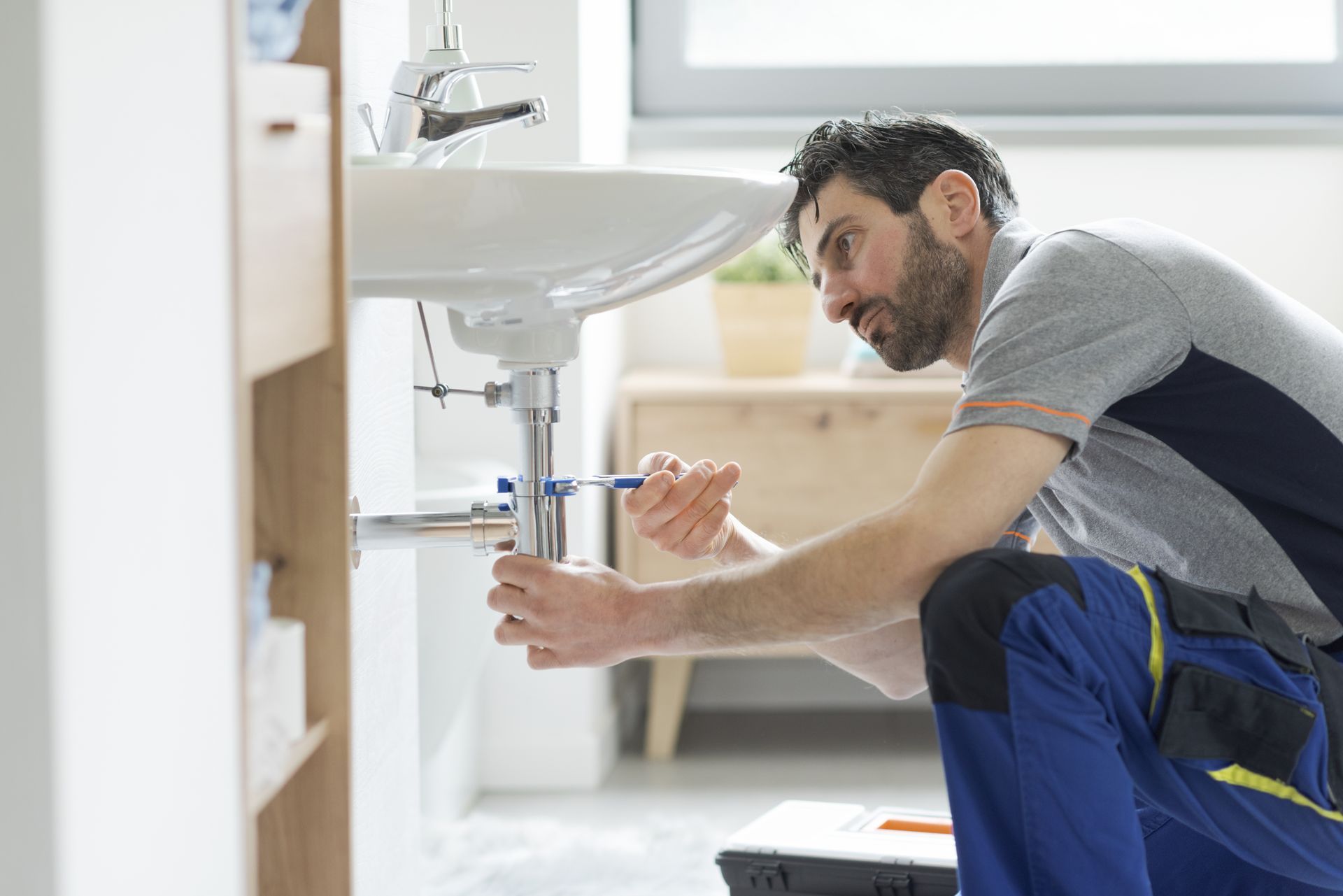 Licensed residential plumber fixing a bathroom sink.