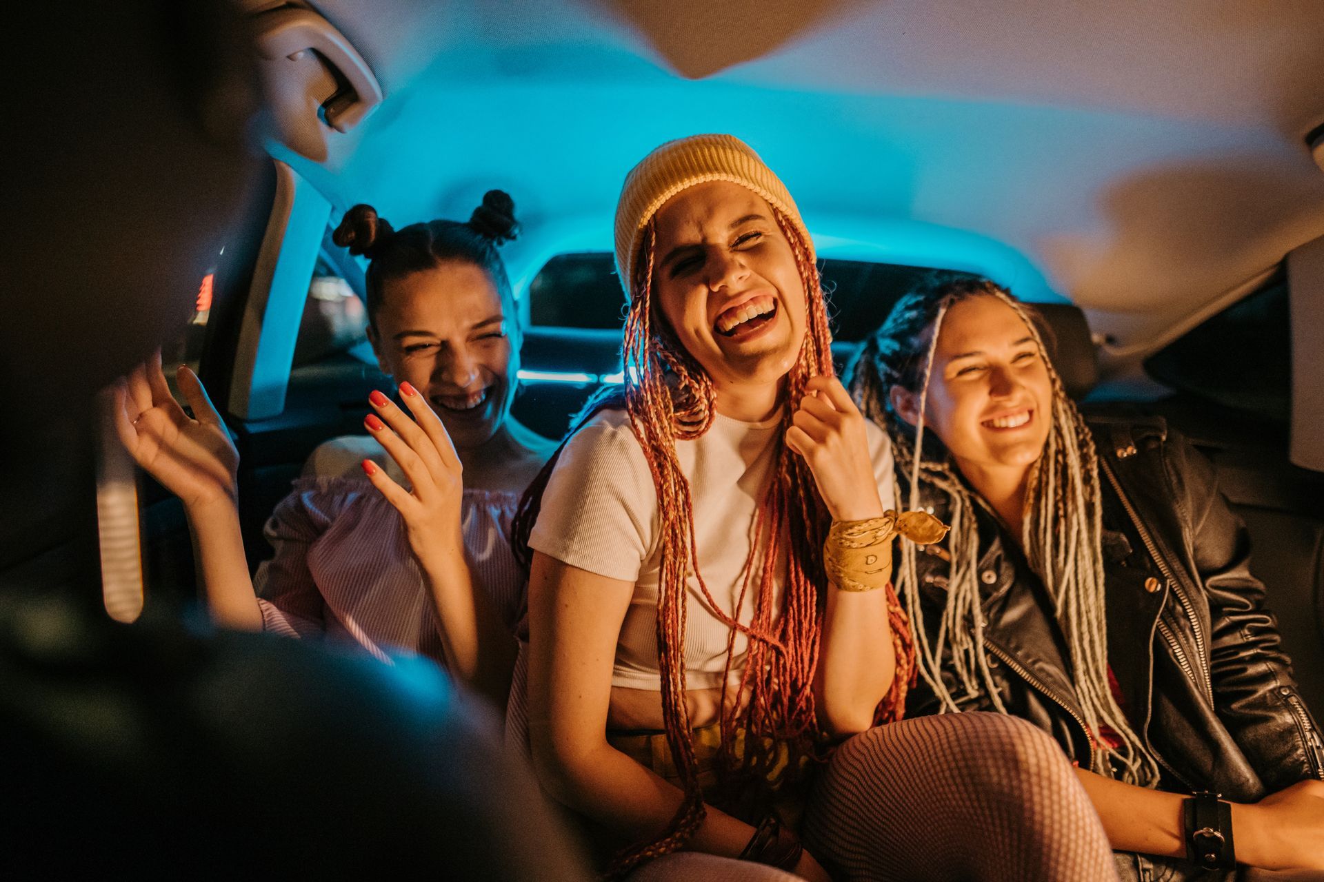 A group of young women are sitting in the back seat of a car. A group of young women are sitting in the back seat of a car.
