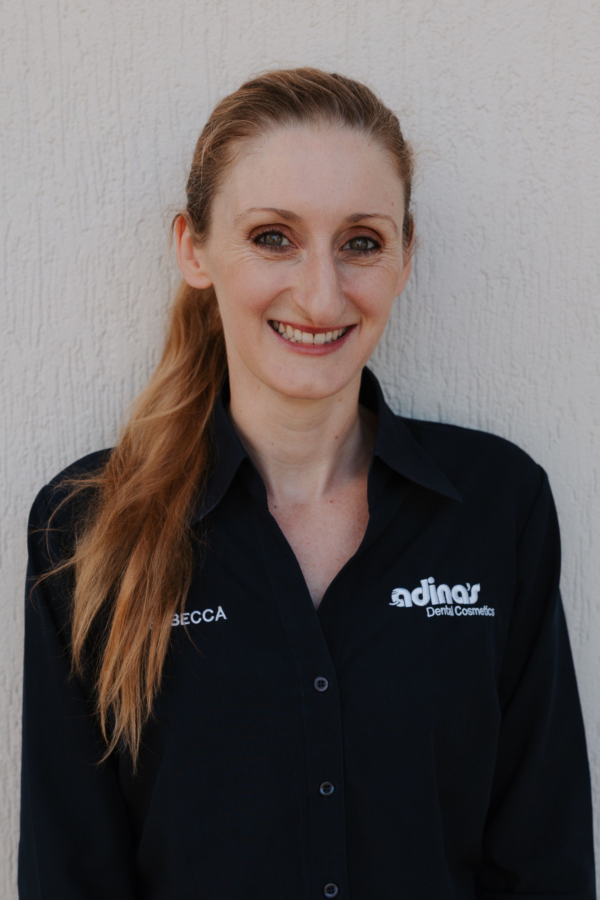 A group of people are posing for a picture in front of a building.