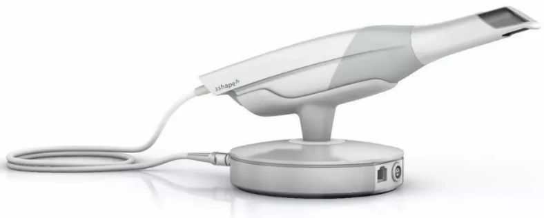 A white tooth scanner is sitting on top of a charger.