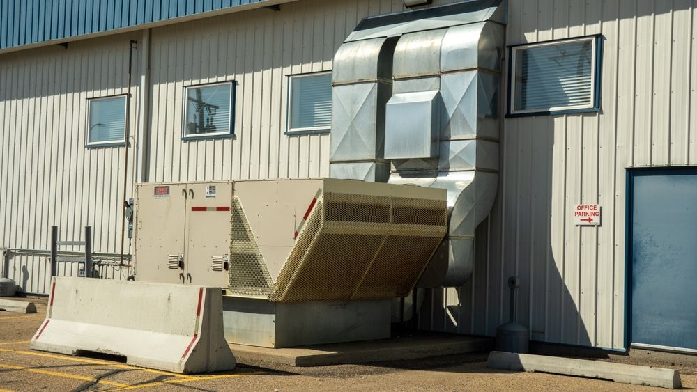 A building with a ventilation system attached to the side of it.