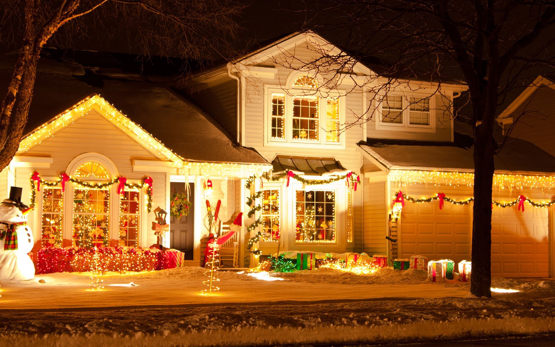 A house is decorated with christmas lights and a snowman