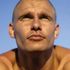 A close up of a man 's face with a blue sky in the background.