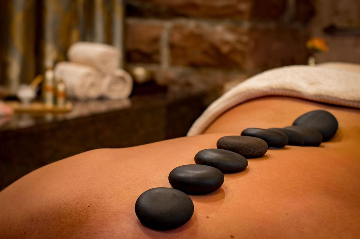 Person in a massage room with hot stones on their back