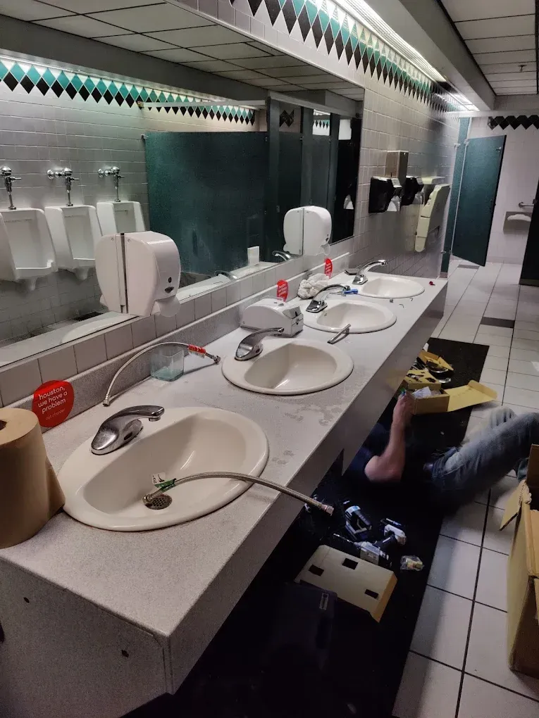 Black, horizontal slats of a pergola cast shadows onto a cream-colored frame.