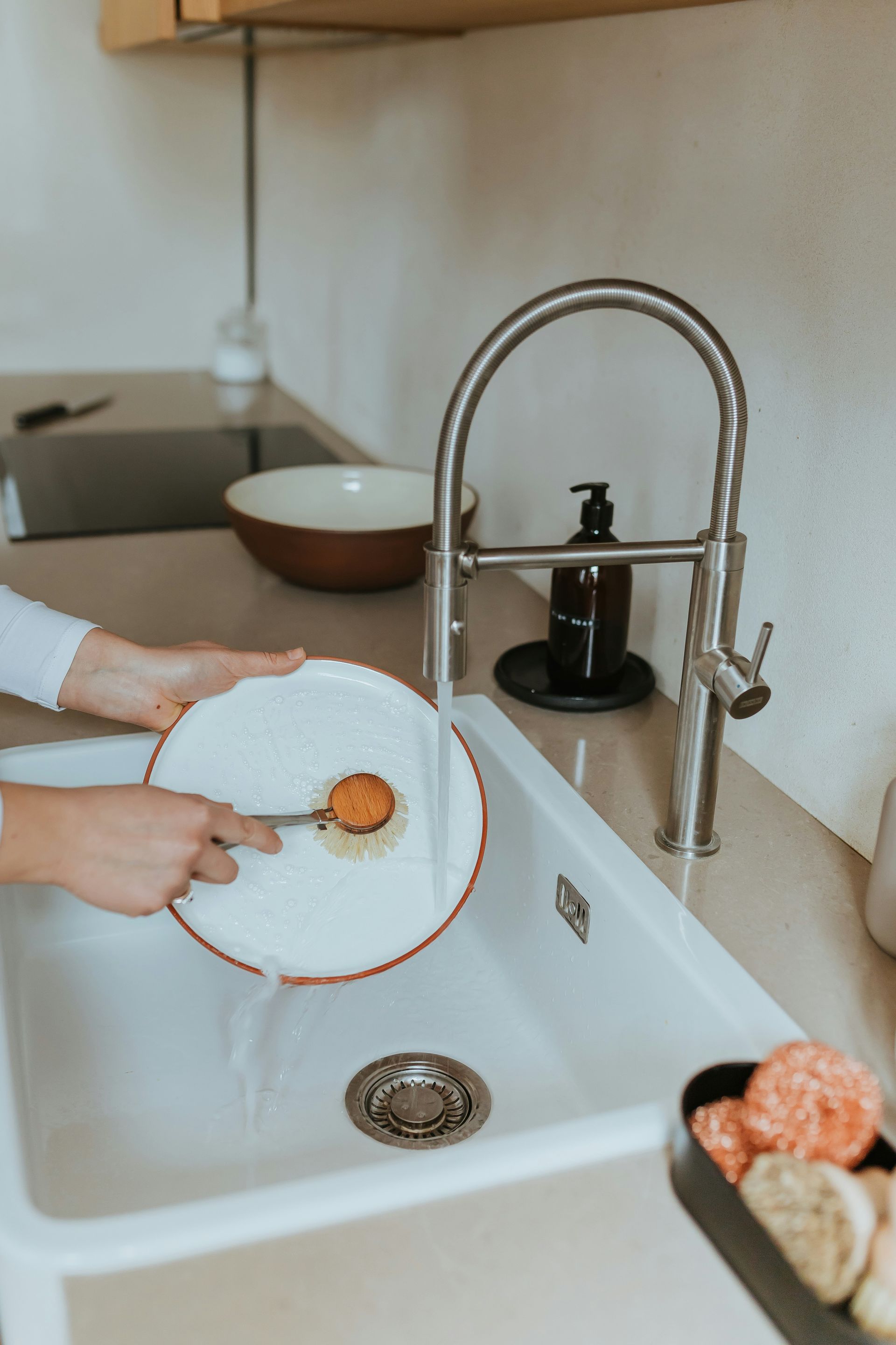 Patio with seating under a slatted pergola, overlooking a grassy backyard.