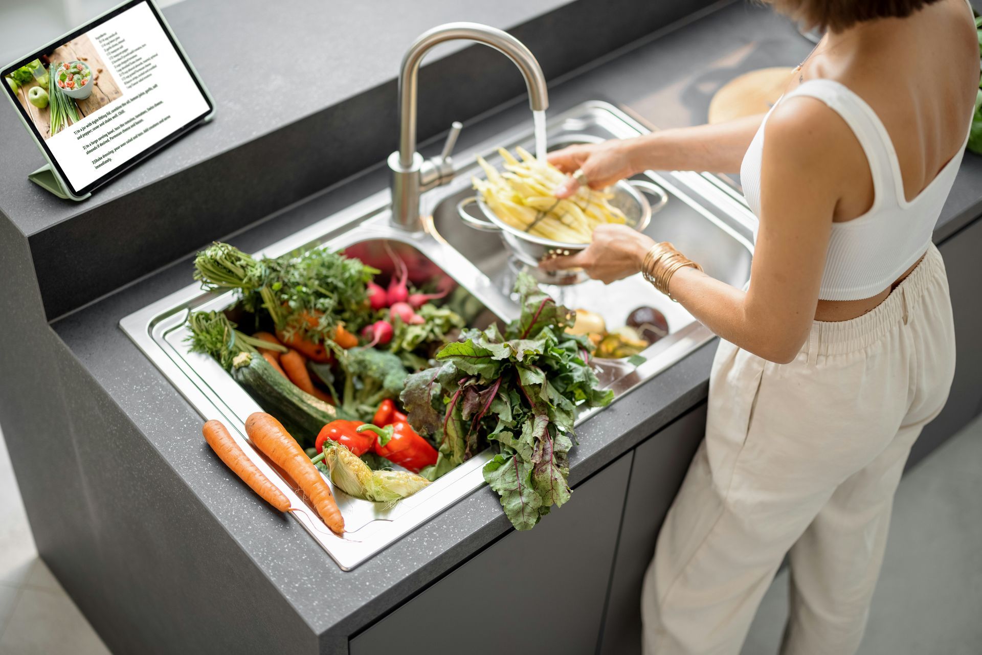 Patio with cream-colored awning overlooking water, furnished with seating and fire pit.