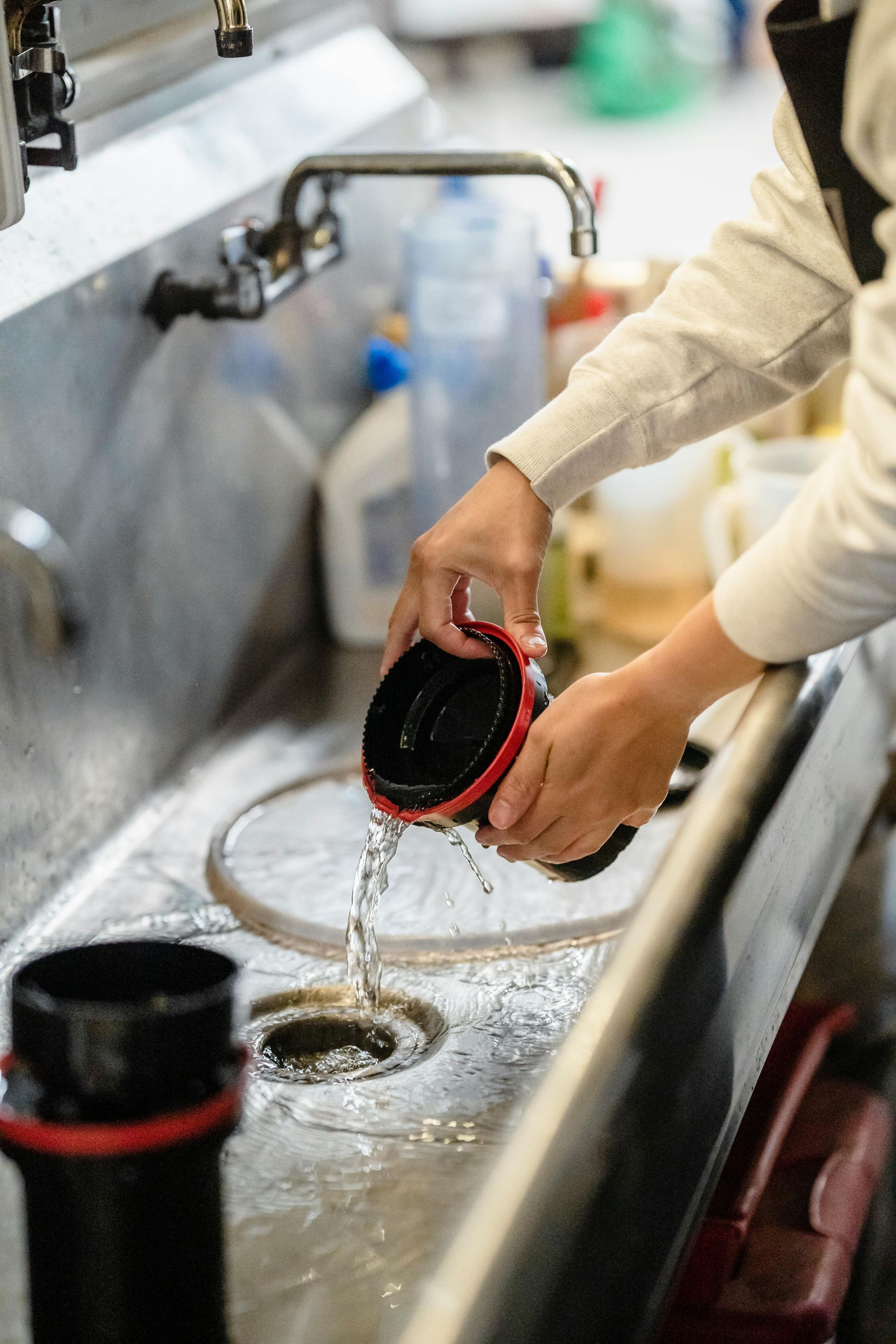 Patio with cream-colored awning overlooking water, furnished with seating and fire pit.