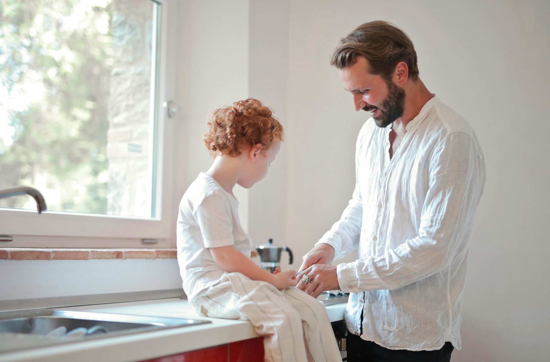 Patio with cream-colored awning overlooking water, furnished with seating and fire pit.