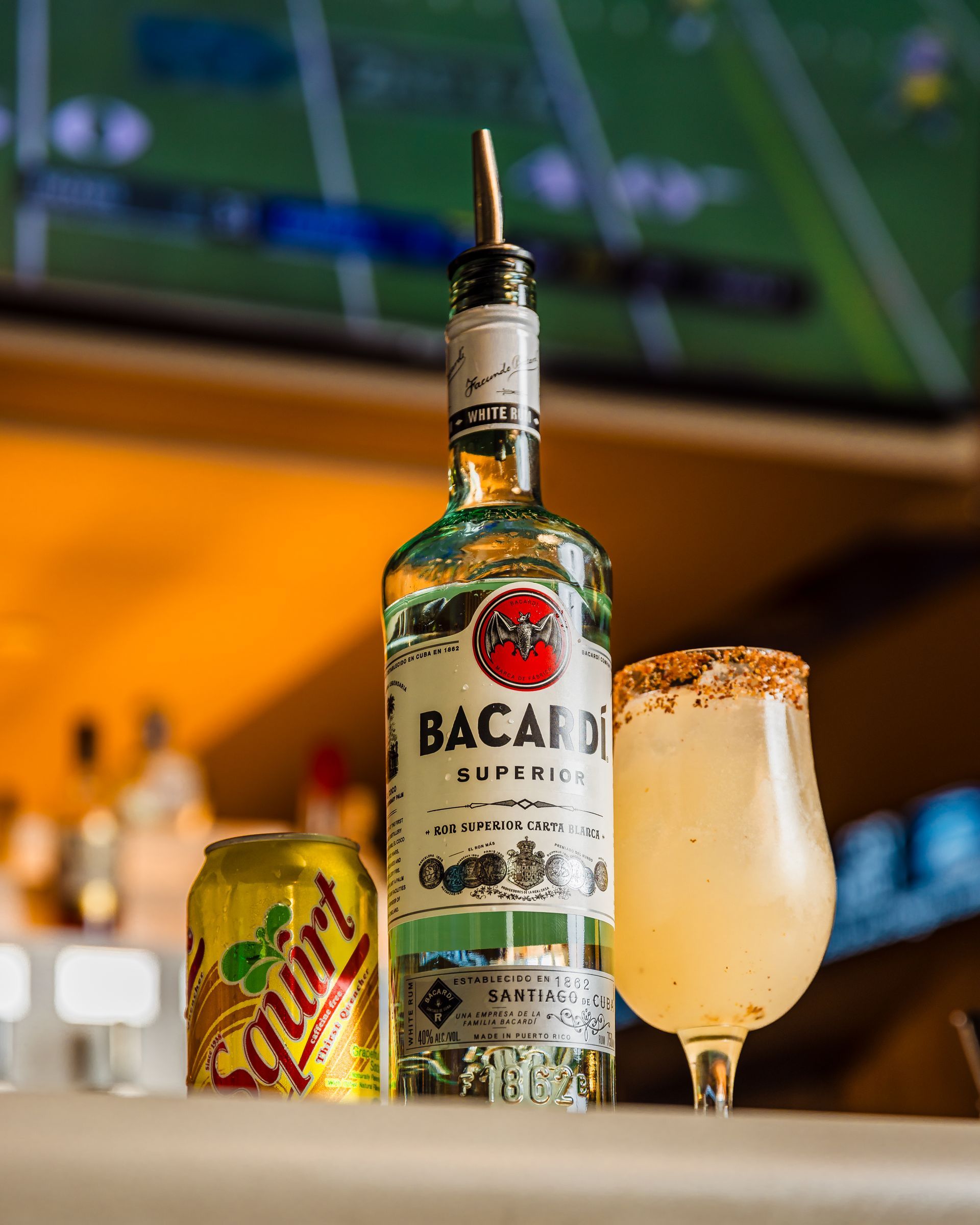 A bottle of bacardi sits next to a glass